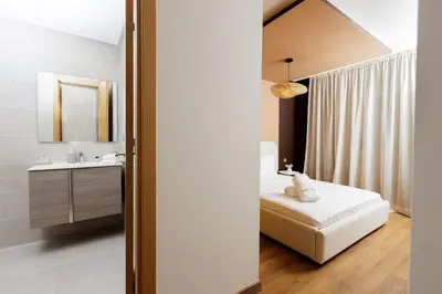 a bedroom with a bed and a sink and a mirror at Luxury 3BR Homelike Stay in Hay Riad in Rabat