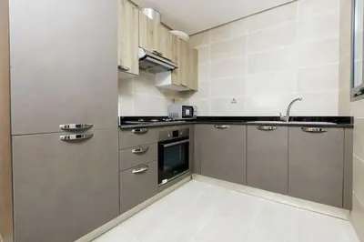 a kitchen with stainless steel appliances and brown cabinets at Luxury 3BR Homelike Stay in Hay Riad in Rabat
