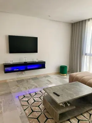 a living room with a flat screen tv and a table at Casablanca in Casablanca