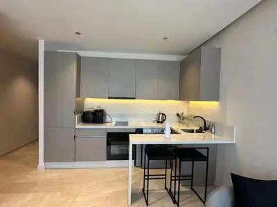 a kitchen with gray cabinets and a table with chairs at Studio Anfa Living 1 in Casablanca