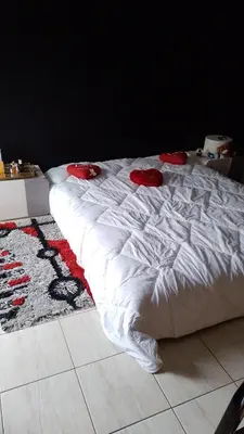 a large white bed with red pillows on the floor at émeraude house family in Casablanca