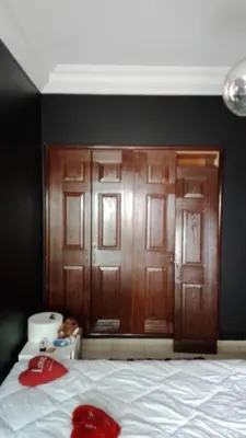 a bedroom with brown wooden doors and a bed at émeraude house family in Casablanca