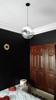 a bedroom with a black wall and aendant light at émeraude house family in Casablanca