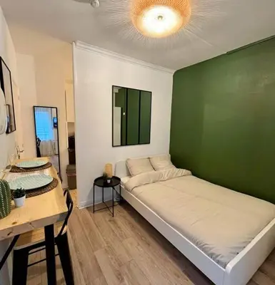 a room with a green wall with a bed in it at studio in Casablanca