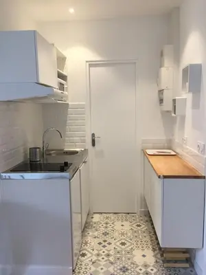 a small white kitchen with a sink and a door at studio in Casablanca