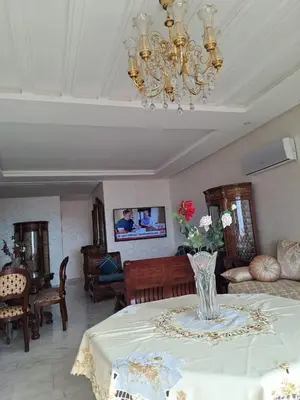 a living room with a table with a vase of flowers at les sables d'or in Temara