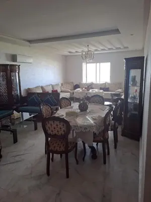 a living room with a table and chairs and a couch at les sables d'or in Temara