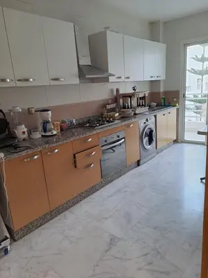 a kitchen with white cabinets and a washing machine at les sables d'or in Temara