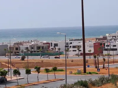 a view of a street with buildings and the ocean at les sables d'or in Temara