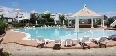 a large swimming pool with chairs and an umbrella at villa pour location vacances in Tamaris