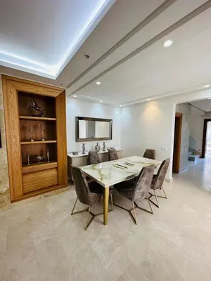 a dining room with a wooden table and chairs at villa pour location vacances in Tamaris