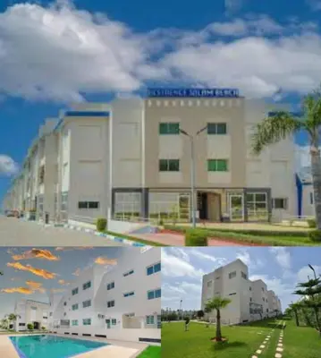 a building with a pool in front of it at Appartement, Salam Beach in Pont Blondin