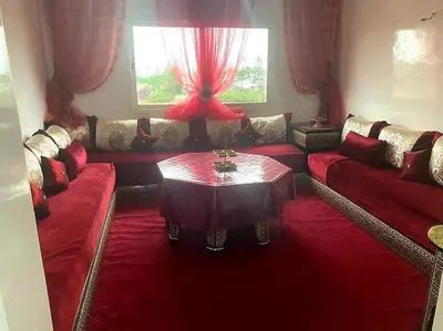 a living room with red couches and a table at Appartement, Salam Beach in Pont Blondin