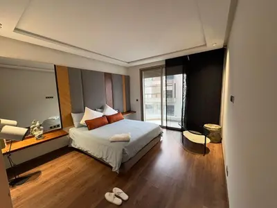 a hotel room with a bed and a large window at Apparemment luxueux casablanca in Casablanca