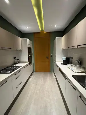 a kitchen with white cabinets and a wooden door at Apparemment luxueux casablanca in Casablanca