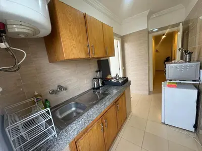 a kitchen with a sink and a white refrigerator at appartement exceptionnel vue sur mer pour famille uniquement in Rabat