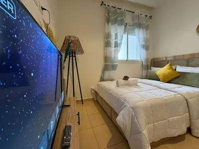 a bedroom with a bed and a flat screen tv at appartement exceptionnel vue sur mer pour famille uniquement in Rabat
