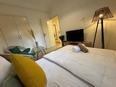 a bedroom with a large white bed and a television at appartement exceptionnel vue sur mer pour famille uniquement in Rabat
