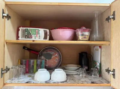 a wooden cabinet filled with dishes and other kitchen items at appartement exceptionnel vue sur mer pour famille uniquement in Rabat