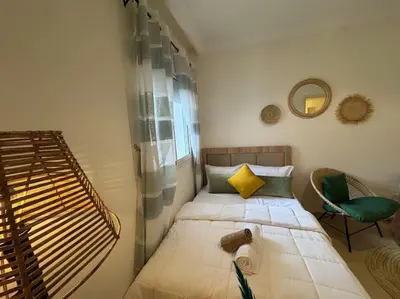 a small bedroom with a bed and a chair at appartement exceptionnel vue sur mer pour famille uniquement in Rabat