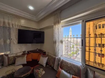 a living room with a couch and a large window at Casablanca mosquée hassan 2 in Casablanca