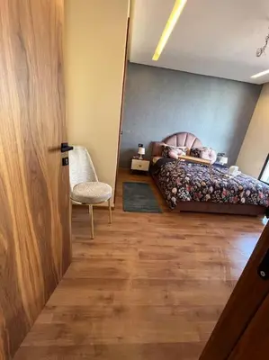 a bedroom with a bed and a chair and a door at Perfect stay at CFC near Aeria Mall in Casablanca