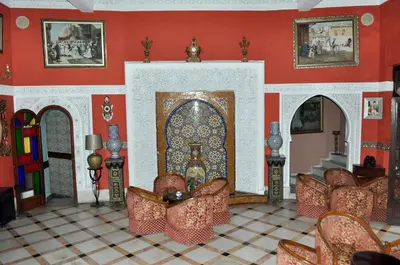 a room with red walls and chairs and a doorway at Hôtel Volubilis in Casablanca