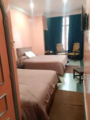 a hotel room with two beds and a couch at Hôtel Volubilis in Casablanca