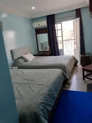 two beds in a room with a mirror at Hôtel Volubilis in Casablanca