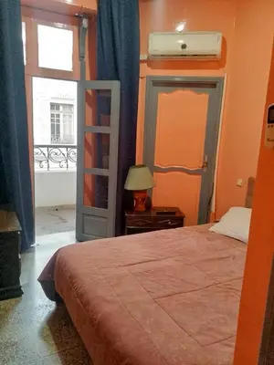 a bedroom with a bed and a window and a lamp at Hôtel Volubilis in Casablanca