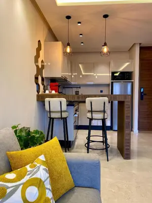 a kitchen with a couch and two bar stools at Confort & Charme à Casablanca in Maarif