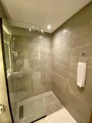 a bathroom with a shower with a glass door at Confort & Charme à Casablanca in Maarif