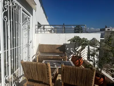 a patio with two chairs and a table on a balcony at La terrasse Agdal in Rabat