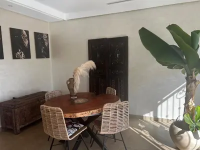 a dining room with a wooden table and chairs at La terrasse Agdal in Rabat