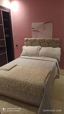 a bed in a bedroom with a red wall at Appartement haut standing in Casablanca