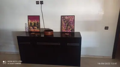 a black dresser with two pictures on top of it at Appartement haut standing in Casablanca