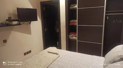 a bedroom with a bed and a tv and a closet at Appartement haut standing in Casablanca