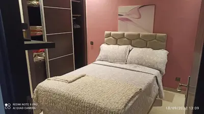 a bedroom with a bed in a room with pink walls at Appartement haut standing in Casablanca