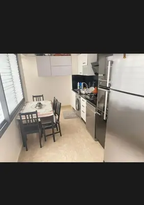 a small kitchen with a table and a refrigerator at 2 bedroom cozy apartment ,near CFC,in center casablanca in Casablanca