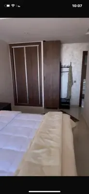 a bedroom with a bed and wooden cupboards at أجمل شقة الوفاق in Temara