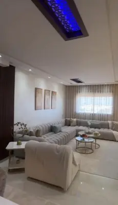 a living room with couches and a blue ceiling at أجمل شقة الوفاق in Temara