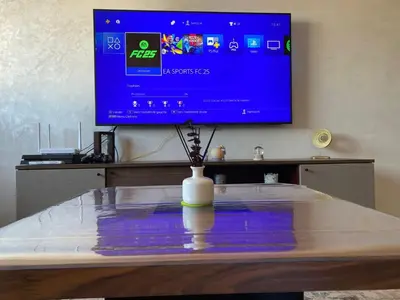 a tv sitting on top of a table with a vase at Cozy apartment in Mohammedia in Mohammedia