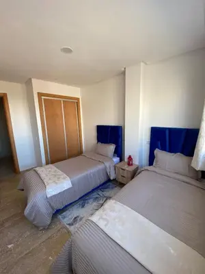 two beds in a room with blue accents at Cozy apartment in Mohammedia in Mohammedia
