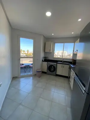 a large kitchen with a view of a balcony at Cozy apartment in Mohammedia in Mohammedia