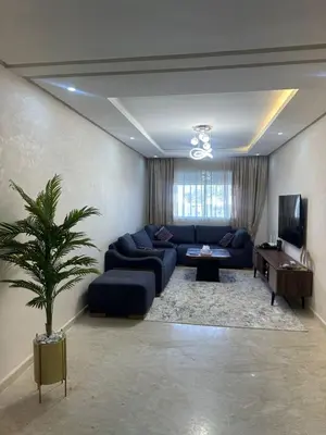 a living room with a blue couch and a tv at Cozy apartment in Mohammedia in Mohammedia