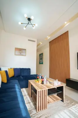 a living room with a blue couch and a table at Emplacement Central Lumineux & Chic Prés de Station Tramway KFC Et Carrefour Abdelmoumen Et 2 Mars Casablanca in Casablanca