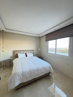 a white bedroom with a large bed and a window at Ksar Labhar City Escape in Rabat