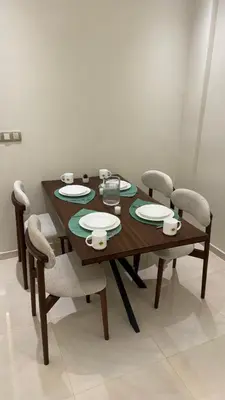 a wooden table and chairs with plates and cups on it at Ksar Labhar City Escape in Rabat