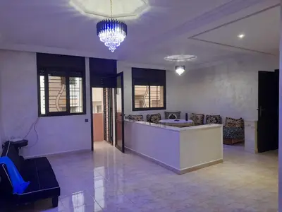 a lobby with a bar and chairs and a chandelier at Apartament Ines in Skhirat
