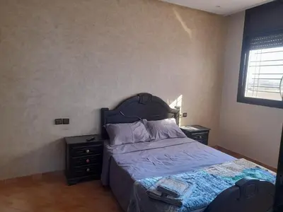 a bedroom with a bed and two night stands at Apartament Ines in Skhirat